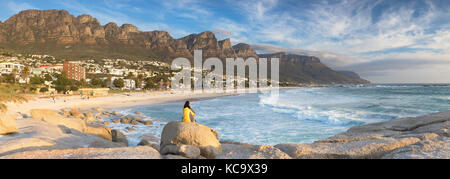 Femme assise sur des rochers à Camps Bay, Cape Town, Western Cape, Afrique du Sud (M.) Banque D'Images