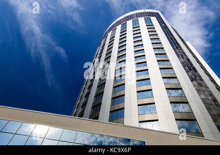 La perspective et l'angle de vue de dessous de verre fond texturé moderne bâtiment gratte-ciel sur blue cloudy sky