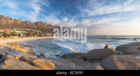 Femme assise sur des rochers à Camps Bay, Cape Town, Western Cape, Afrique du Sud (M.) Banque D'Images