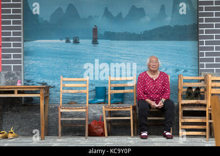 Du vrai personnes âgées personnes asiatiques, vieille femme chinoise de xianggong Hill, près de Yangshuo, Guangxi, Chine, Asie assis à l'extérieur d'un restaurant Banque D'Images