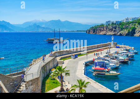 Antalya, Turquie - 12 mai 2017 : la jetée et phare de vieux port à Kaleici avec yacht à voile et de montagnes énormes sur l'arrière-plan, le 12 mai Banque D'Images
