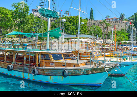 La vue sur les remparts historiques de la forteresse d'Antalya à travers les voiles des yachts et bateaux de plaisance amarrés dans le vieux port de plaisance, la Turquie. Banque D'Images