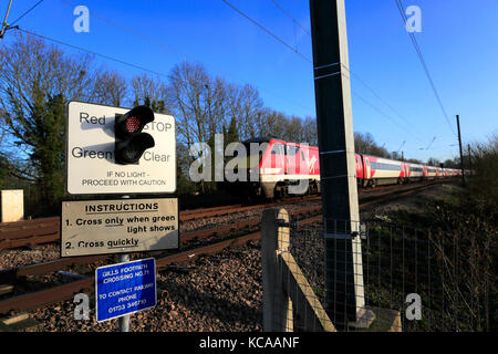 Train les feux rouges à un passage à niveau sans pilote, Offord Cluny Village, East Coast Main Line Railway, Cambridgeshire, Angleterre, RU Banque D'Images