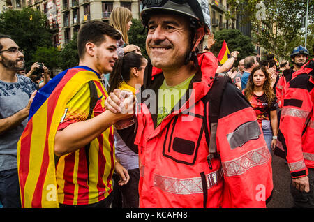 Barcelone, Espagne. 3ème Oct 2017. Un pompier reçoit les félicitations d'un jeune partisan de l'indépendance après l'action de protestation. Des centaines de pompiers ont été dirigés vers le siège de la délégation du Gouvernement à Barcelone pour montrer leur rejet de la répression subie lors du dernier référendum le jour 1-O Banque D'Images