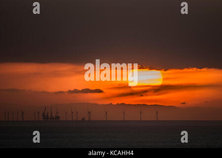 Eastbourne, East Sussex, Royaume-Uni. 3 octobre 2017. Météo britannique. Coucher de soleil sur le parc éolien offshore de Rampion dans la Manche vue de la zone de Beachy Head sur les South Downs. Banque D'Images