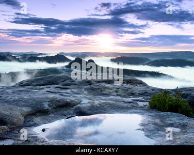 Paysage dans l'eau miroir. misty réveil dans belles montagnes parc. sommets de collines en vallée pleine de brouillard après de fortes pluies Banque D'Images