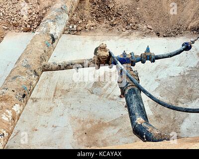 Fouille. vieux 500mm boire de l'eau tuyau avec 150mm bras de virage avec robinets-vannes, raccords tubes corrodés rejoindre. tuyauterie avant réparation. asphal Banque D'Images