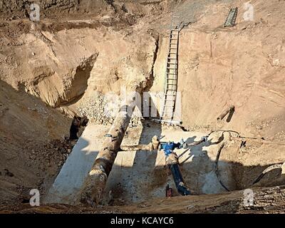 Fouille. vieux 500mm boire de l'eau tuyau avec 150mm bras de virage avec robinets-vannes, raccords tubes corrodés rejoindre. tuyauterie avant réparation. asphal Banque D'Images