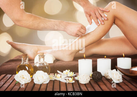 Close-up d'un thérapeute Waxing Female Customer's Leg Beauty Spa Banque D'Images