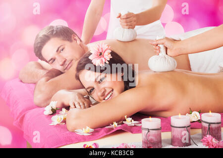 Jeune couple Getting Massage avec Herbal Compresser Balls sur le dos à Beauté Spa à Spa Banque D'Images