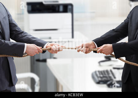 Close-up of a Businessman Hand jouer remorqueur de la guerre In Office Banque D'Images