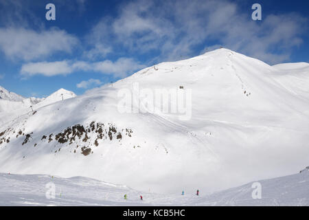 Skieurs et Snowboarders freeride et descente sur trace montagnes avec des nuages à sun journée froide. montagnes du Caucase en hiver, la Géorgie, la région gudauri. Banque D'Images