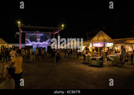 Une étape dans la zone d'amusement au marché de nuit de Phnom Penh, avec un chanteur qui chante à la petite foule d'acheteurs en face de lui. Le Cambodge, l'Asie du Sud-Est Banque D'Images