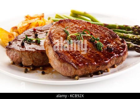 Les steaks grillés,copeaux et les asperges sur fond blanc Banque D'Images