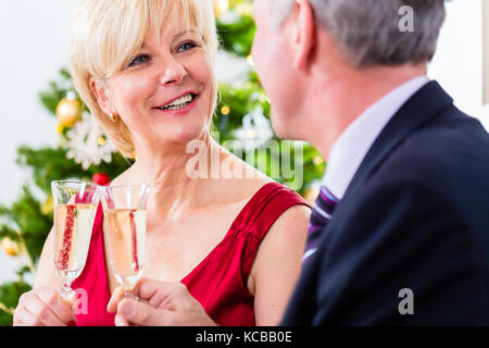 Senior couple celebrating christmas with champagne Banque D'Images