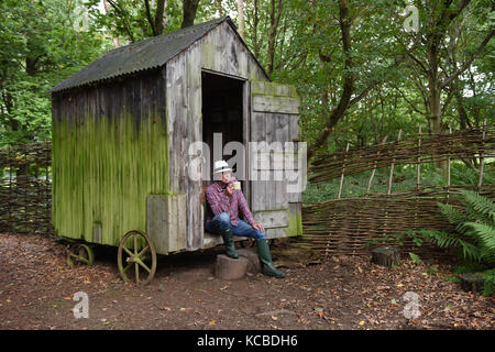 Homme se détendant dans un jardin boisé hanté sur Wheels Britain Royaume-Uni isolement isolé refuge rural retraite Banque D'Images