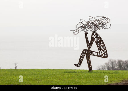 Une sculpture de métal d'hommes dans un champ stylisée Banque D'Images