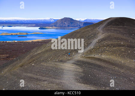 Randonneur à Hverfell (également appelé Hverfjall), cône de tephra ou anneau de tuf volcan avec lac Mývatn en arrière-plan. Islande. Banque D'Images