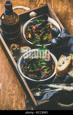 Les moules cuites belge à la sauce tomate et de la bière en bouteille Banque D'Images