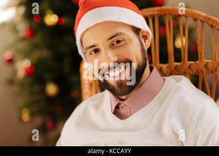 Bel homme à Santa hat smiling at camera Banque D'Images