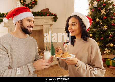 Heureux couple holding biscuits et du lait Banque D'Images