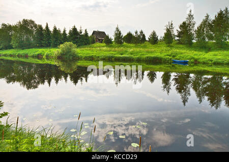 Vue sur la rivière avec des arbres et de bush sur Riverside se reflétant dans les eaux calmes de la Carélie, RUSSIE.. Banque D'Images