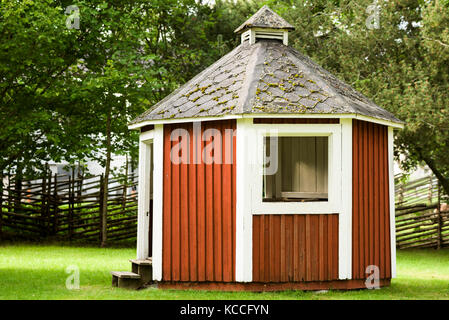 Petit rouge gazebo dans parc public. clôture poteau en arrière-plan. Banque D'Images