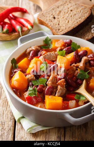 Compotée de potiron avec les haricots, la viande, les tomates et le piment fort libre dans un pot sur la table verticale. Banque D'Images