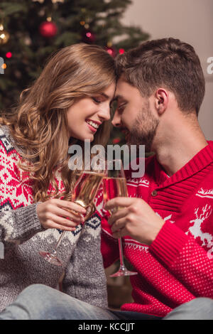 Couple drinking champagne at Christmas Banque D'Images