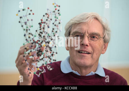 Richard Henderson, qui est l'un des trois scientifiques qui ont partagé le prix Nobel de chimie 2017 pour l'amélioration des images faites de molécules biologiques, examine un modèle d'une bactériorhodopsine, comme il parle au Laboratoire de biologie moléculaire à Cambridge, où il travaille. Banque D'Images