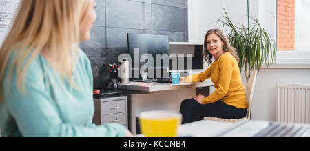 Deux femme assise au bureau et de parler à l'office Banque D'Images