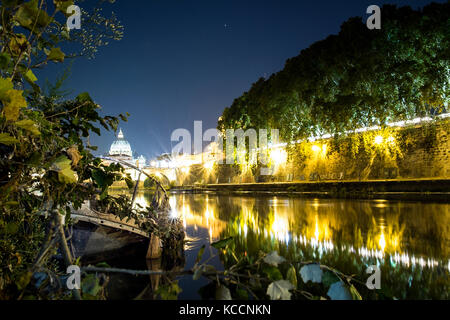 Belle vue de la nuit de la Basilique Saint Pierre. Photo prise sur les rives du Tibre, avec un vieux bateau en premier plan Banque D'Images