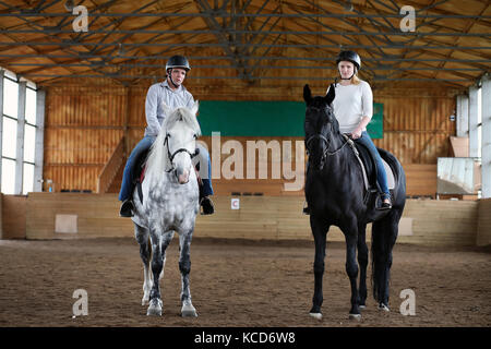 Les gens sur un cheval de la formation dans une arène en bois Banque D'Images