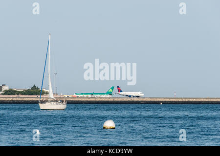 Boston USA 06.09.2017 - vue du bateau à voile en face de l'aéroport international Logan et prêt pour le décollage des avions delta Banque D'Images