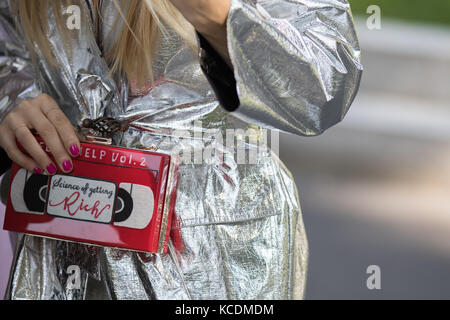 Milan, Italie - 22 septembre 2017 : modèle portant un manteau argenté sac à main et une cassette vidéo pendant le défilé armani, photographié dans la rue Banque D'Images