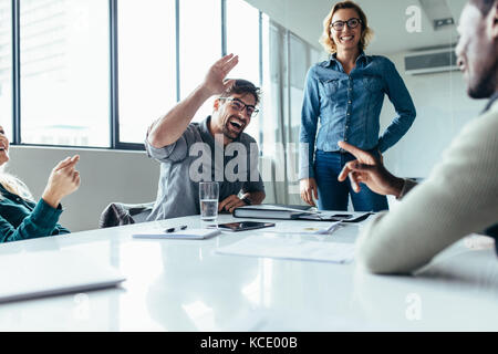 Businessman offrant un cinq à un collègue au cours d'une réunion dans la salle de conférence. Salle de positif pour l'environnement. Banque D'Images