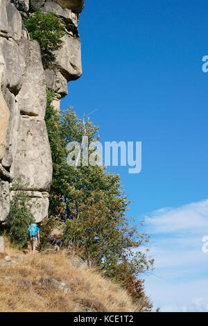 Homme avec sac à dos randonnée sous une formation naturelle de grès ressemblant étrangement au profil d'un homme. Annot, Alpes-de-haute-Provence, France. Banque D'Images