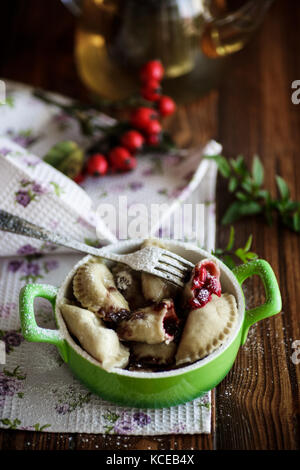 Sweet quenelles avec les cerises dans un bol Banque D'Images