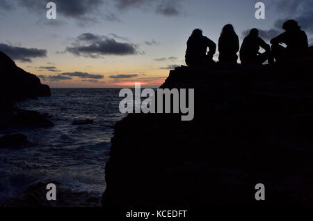 Crépuscule à Droskyn Point, Broad Oak, Cornwall, avec quatre personnes qui se profile dans le crépuscule. Banque D'Images