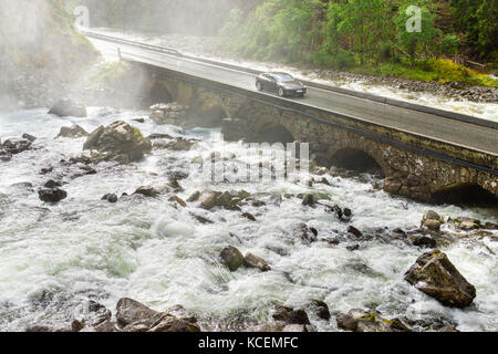 Voiture électrique la conduite sur bridge crossing river. l'énergie renouvelable à partir d'énergie hydraulique concept. Banque D'Images