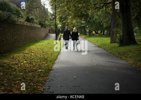 Couple d'âge mûr, se tenant la main, se promener ensemble le long, calme, pittoresque, bordée d'un sentier Riverside au début de l'automne - Nouveau chemin à pied, York, Angleterre, Royaume-Uni. Banque D'Images