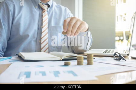 Close-up of Businessman putting coin de la hausse pile de pièces. Banque D'Images