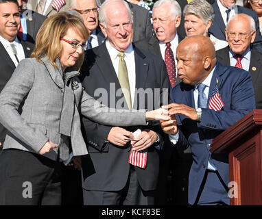 L'ancienne représentante des États-Unis Gabrielle Giffords (démocrate de l'Arizona), à gauche, est accueillie par le représentant américain John Lewis (démocrate de Géorgie), à droite, alors qu'elle arrive rejoindre les démocrates de la Chambre des représentants américains alors qu'ils apparaissent sur les marches est du Capitole américain pour faire une déclaration contre la violence armée à la suite du massacre de Las Vegas à Washington, DC le mercredi 4 octobre 2017. En regardant du centre se trouve le représentant américain Mike Thompson (démocrate de Californie). Crédit : Ron Sachs/CNP - AUCUN SERVICE DE FIL - photo : Ron Sachs/Consolidated/dpa Banque D'Images