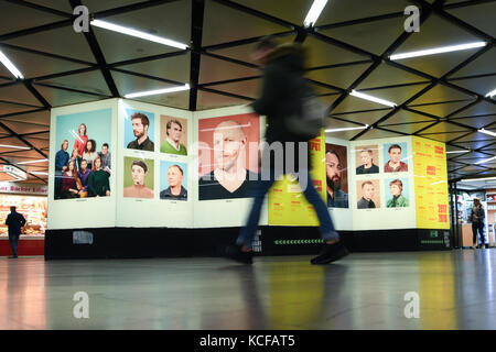 Un passant passe devant des portraits de membres de l'ensemble du théâtre dans la station de métro Willy-Brandt-Platz à Francfort-sur-le-main, Allemagne, le 05 octobre 2017. La refonte a été initiée par les directeurs artistiques de l'opéra et du théâtre. Photo : Arne Dedert/dpa Banque D'Images