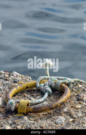 L'anneau de fer avec une corde attachée pour immobiliser des navires et bateaux à quai ou mur du port dans le port de Naxos sur l'île de Corfou. Banque D'Images