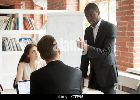 African American employé de se comporter brutalement au cours de réunion d'entreprise. travailleur mécontents à exprimer sa frustration en colère contre ses collègues de travail. busines Banque D'Images