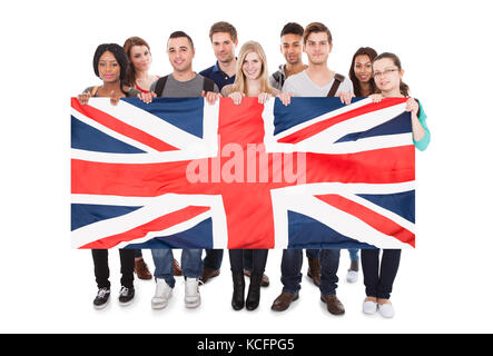 Heureux les jeunes gens Tenant Union Jack contre fond blanc Banque D'Images