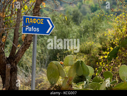 Panneau routier dans le village d'Episkopi écrit en anglais et grec indiquant la direction de Pafos ville de la République de Chypre. Banque D'Images