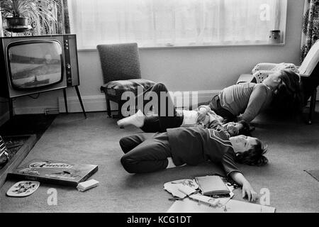 Enfants jouant dans le salon, regardant la télévision. Jeux de société sur le sol. Maison de famille de classe moyenne Leicestershire années 1970 1972 Angleterre. HOMER SYKES Banque D'Images