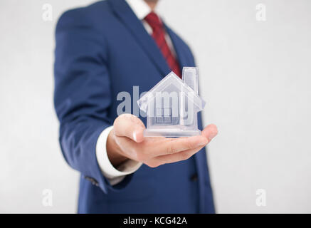 Businessman with crystal house dans la main Banque D'Images